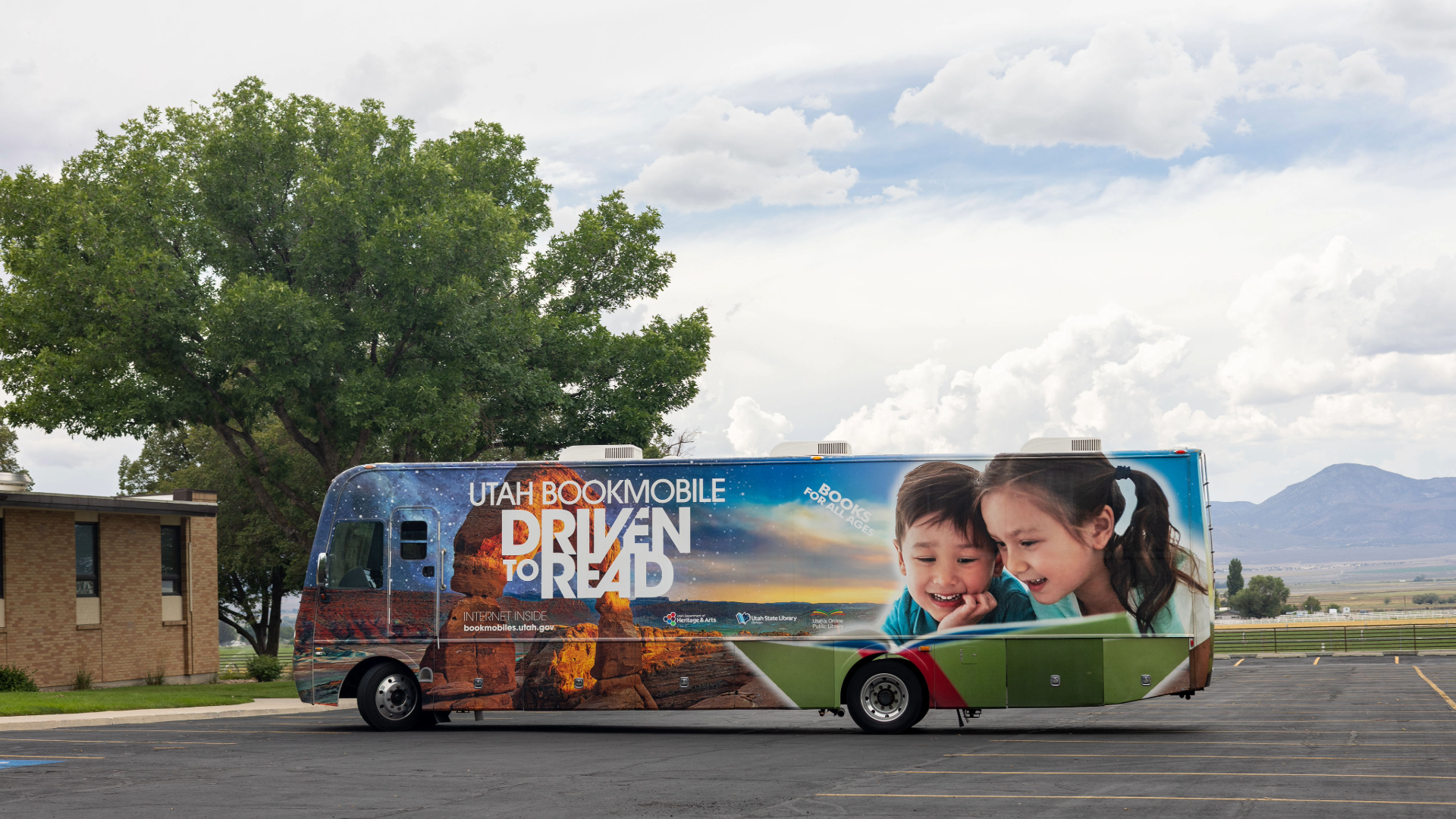 Bookmobile in a parking lot against a cloudy sky